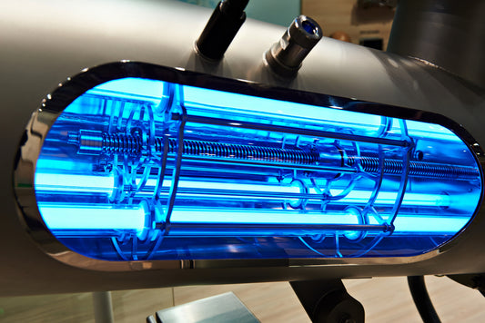 A glass window in a commercial sized pipe shows the UV water treatment system in place to purify the water that passes through