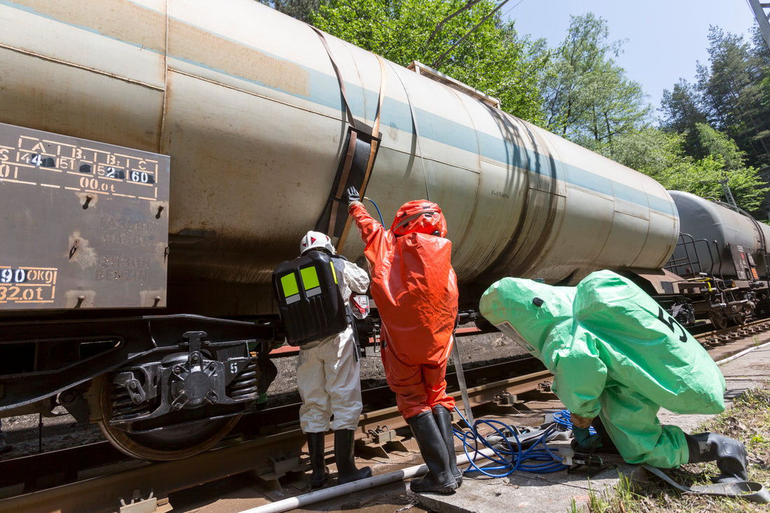 Workers in hazmat suits tending to a train