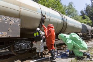Workers in hazmat suits tending to a train