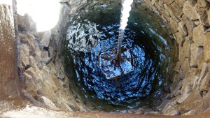 The inside of a well with a bucket pulling up water